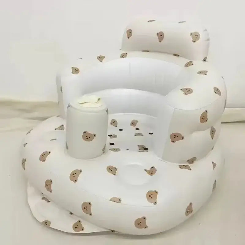 White inflatable baby chair with beige bear face patterns.