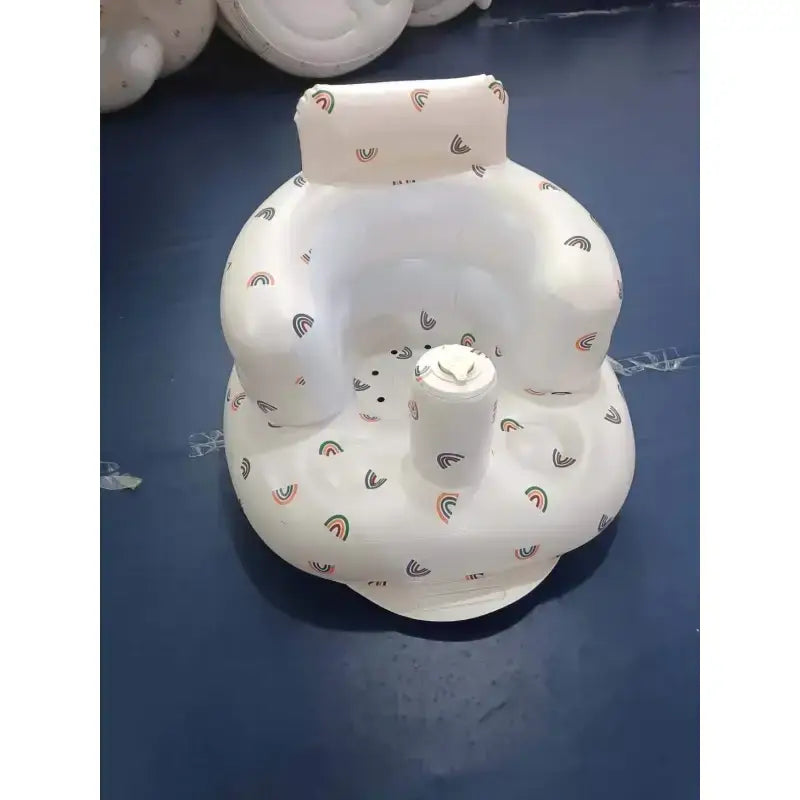 White inflatable baby seat with rainbow pattern.