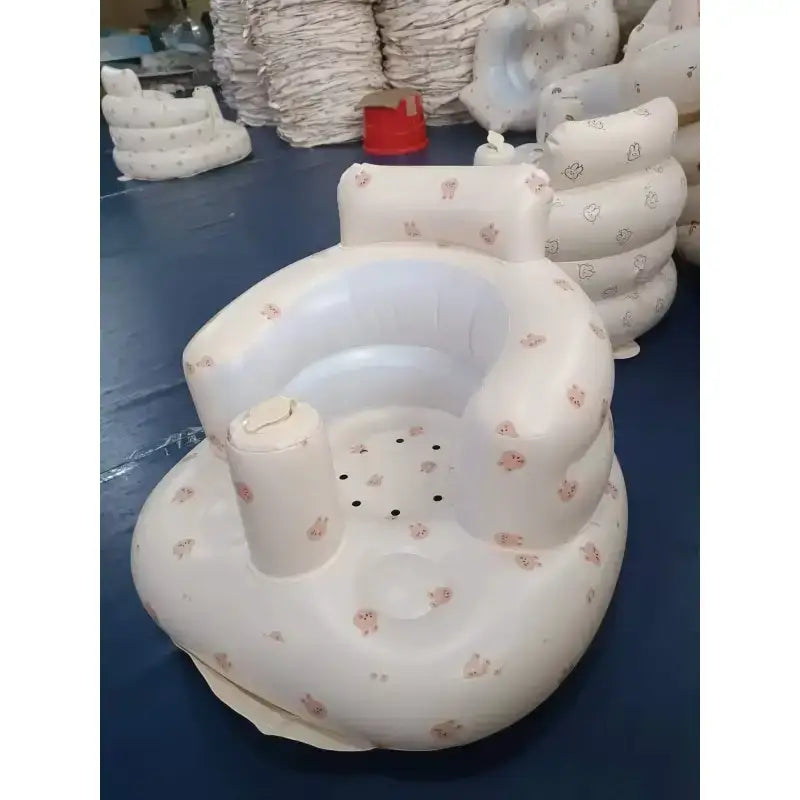 Inflatable baby seat with a soft white exterior adorned with pink cartoon animal prints and a built-in cup holder.