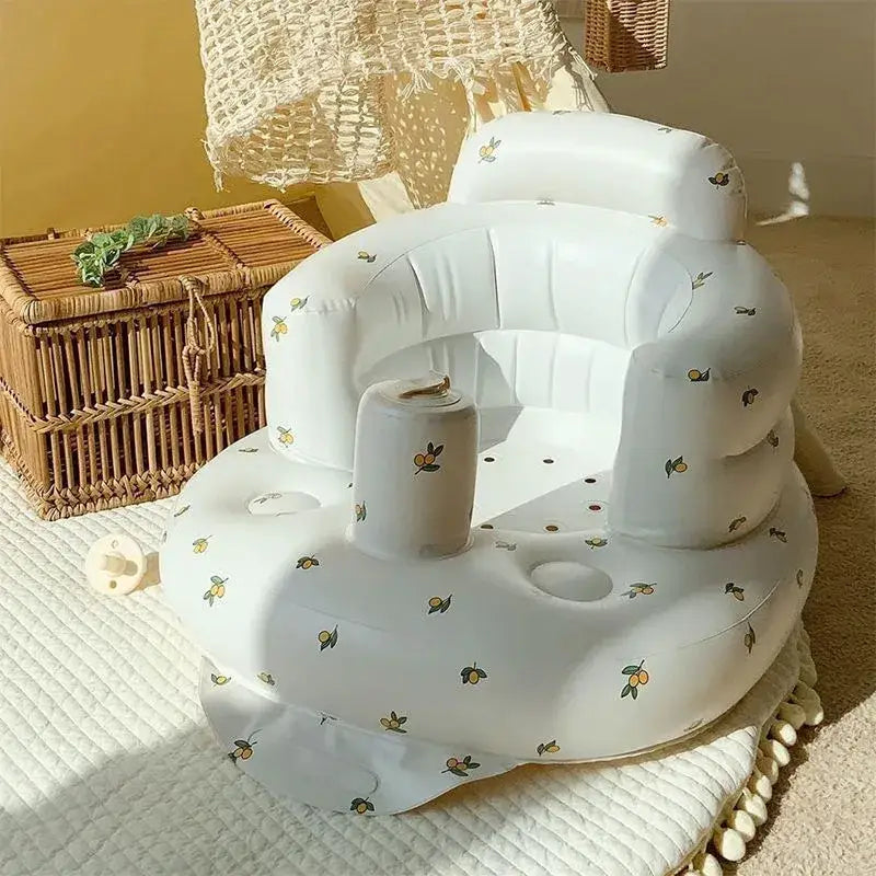 White inflatable baby seat with a lemon pattern and built-in cup holder.