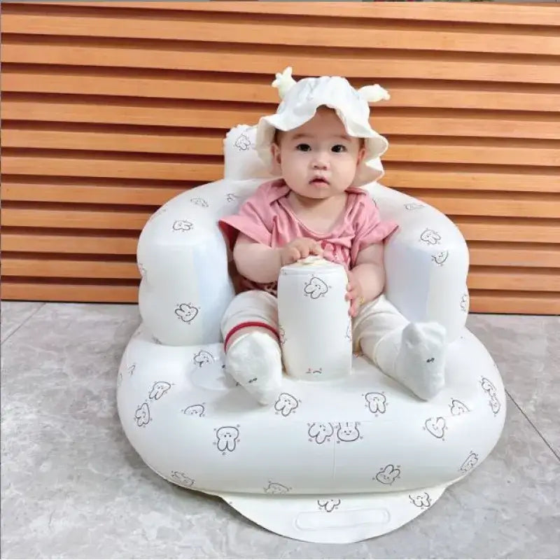 White inflatable baby seat with a playful cartoon pattern.