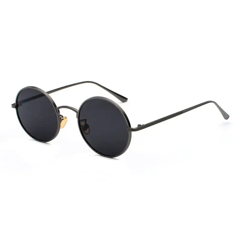 Black round-framed sunglasses with dark lenses and a gold-colored bridge accent.