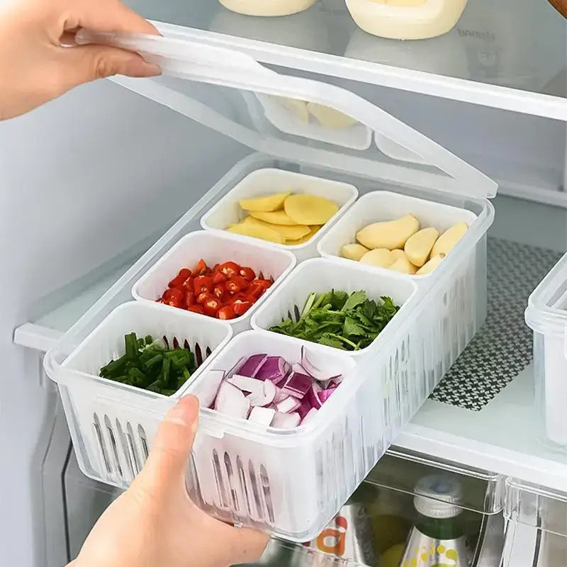 White plastic refrigerator organizer with six compartments holding chopped vegetables and garlic