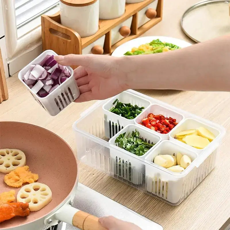 White plastic segmented kitchen organizer with slotted compartments holding chopped vegetables