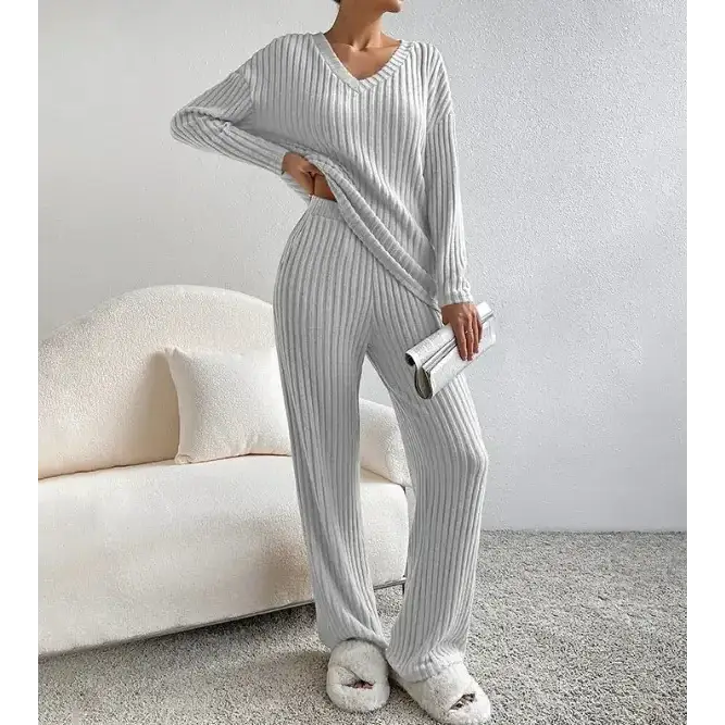 A cozy, light gray ribbed knit pajama set with a v-neck top and matching wide-leg pants.