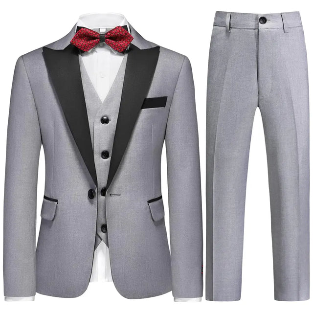 Gray tuxedo suit with black satin lapels and matching vest, accented by a red patterned bow tie.