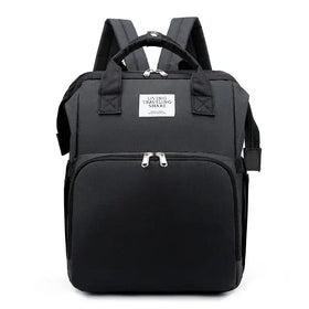 Black fabric backpack with silver zippers and a white label reading ’living traveling share’.