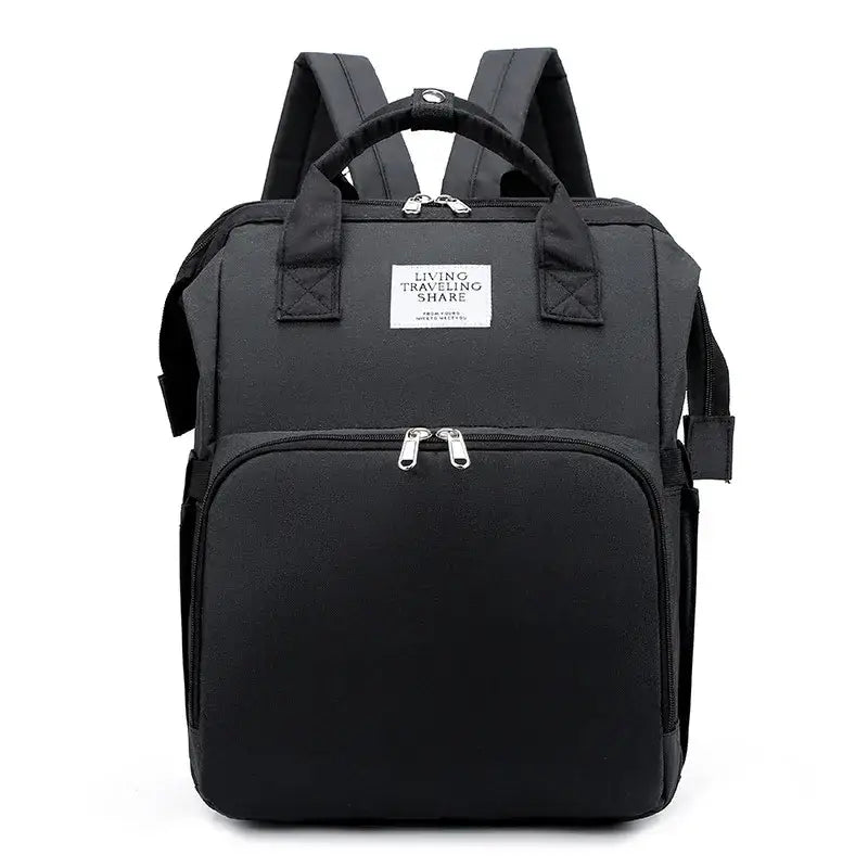 Black fabric backpack with silver zippers and a white label reading ’living traveling share’.
