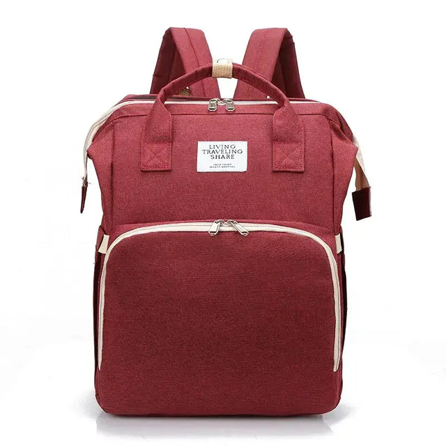 A maroon fabric backpack with beige zipper pulls and trim, featuring a white label that reads ’living traveling share.’