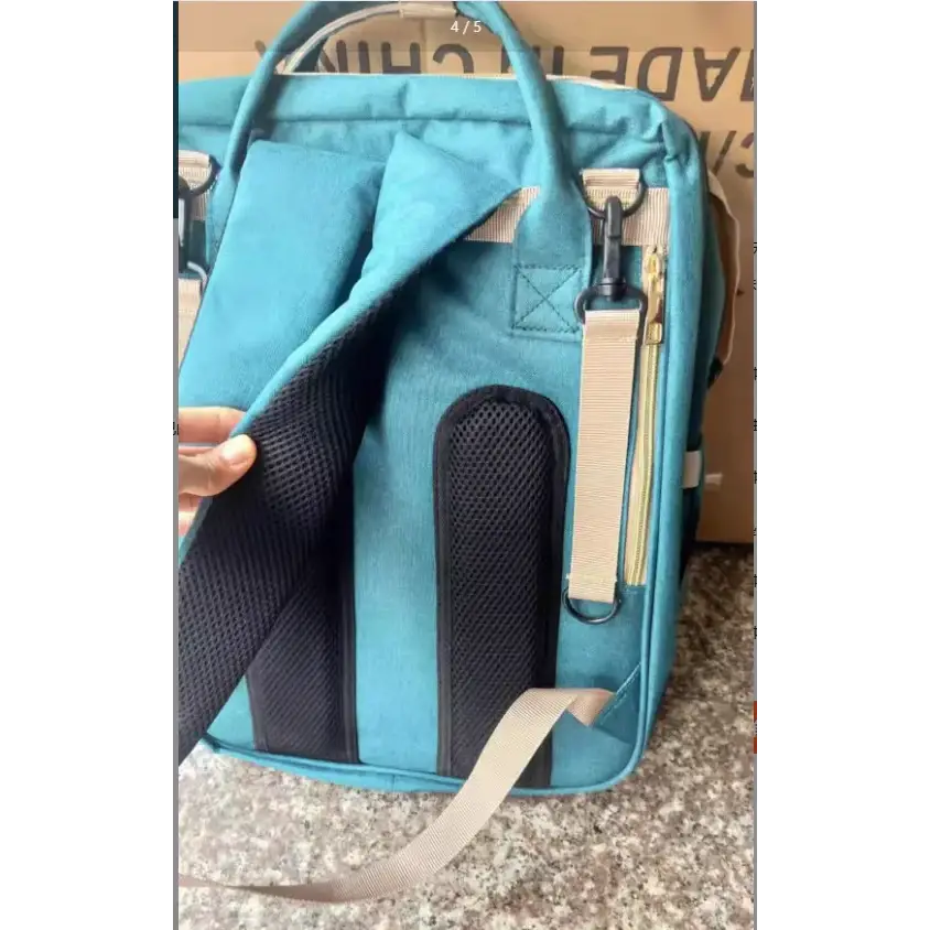 Teal-colored, structured diaper bag with black mesh panels and beige straps.