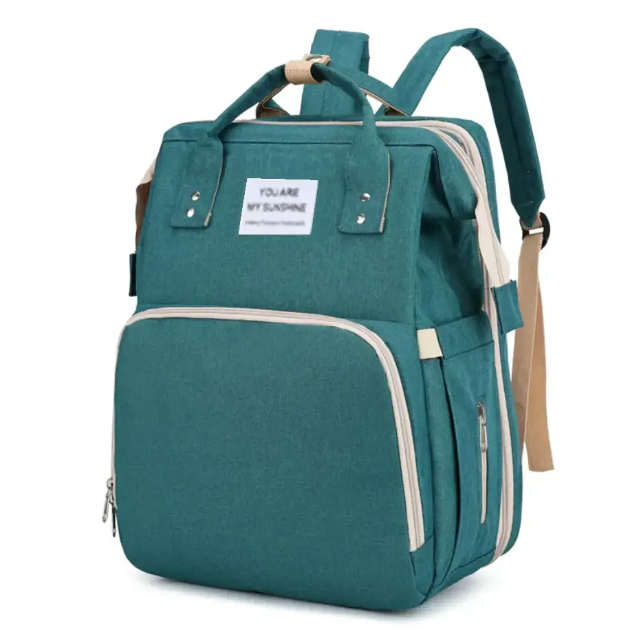 Teal fabric diaper bag with beige trim and a white label reading ’you are my sunshine.’