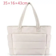 Cream-colored quilted tote bag with structured, padded design and sturdy handles.