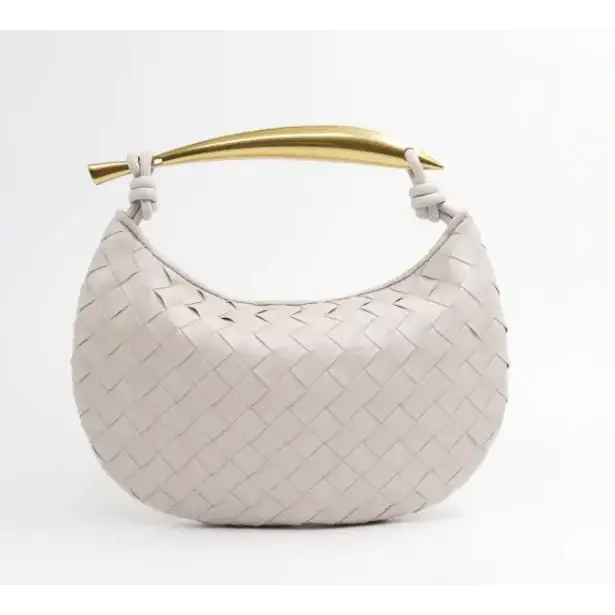 A sleek, off-white woven leather handbag with a polished gold-tone handle.