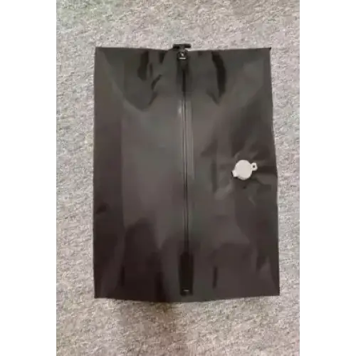Black zippered shoe bag with a white circular pull tab on the side