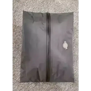 Dark gray fabric shoe bag with a black zipper and a small white embroidered logo on the upper right corner.