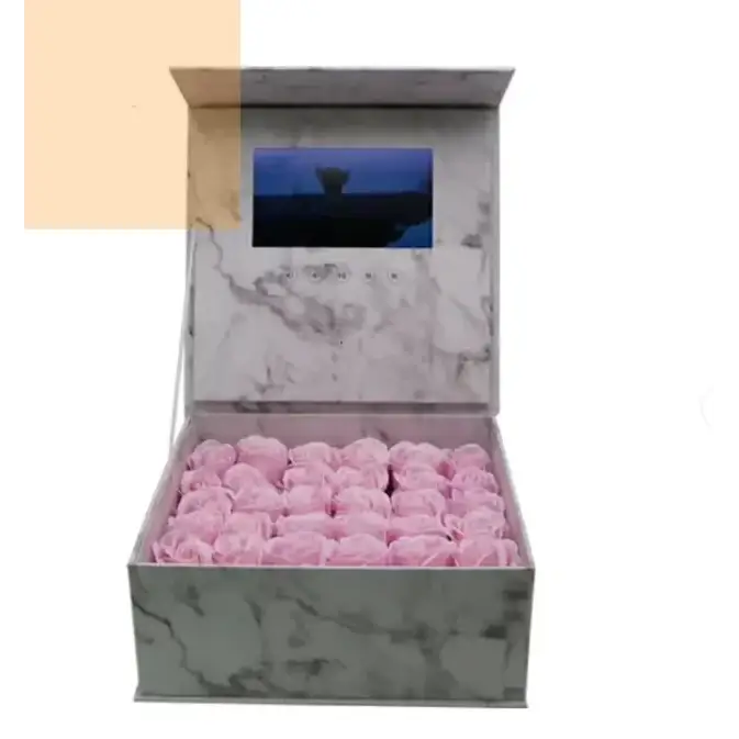 Marble-patterned box containing pink roses with a built-in screen on the lid.