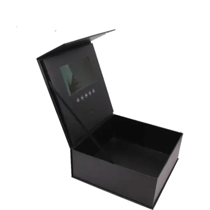 Black rectangular box with a hinged lid, featuring an embedded screen and circular buttons on the inside of the lid.