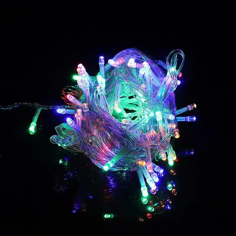 A tangled bundle of colorful led string lights with translucent, glowing bulbs in hues of green, blue, purple, and pink.