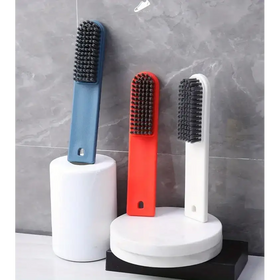 Three colorful, modern shoe brush cleaners with dense black bristles and plastic handles in blue, red, and white.