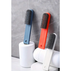 Three colorful scrub brushes with dense black bristles, featuring handles in blue, orange, and white plastic.