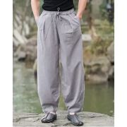 Gray, loose-fitting cotton trousers with an elastic waistband and drawstring.