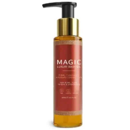 A sleek amber glass bottle of magic luxury body oil with a gold pump and black cap, featuring elegant gold-embossed text on its label.