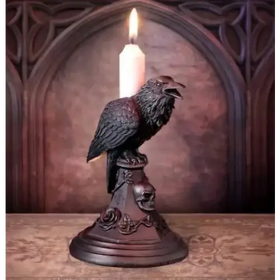 Dark, intricately detailed crow candle holder with a lit white candle perched atop its beak.