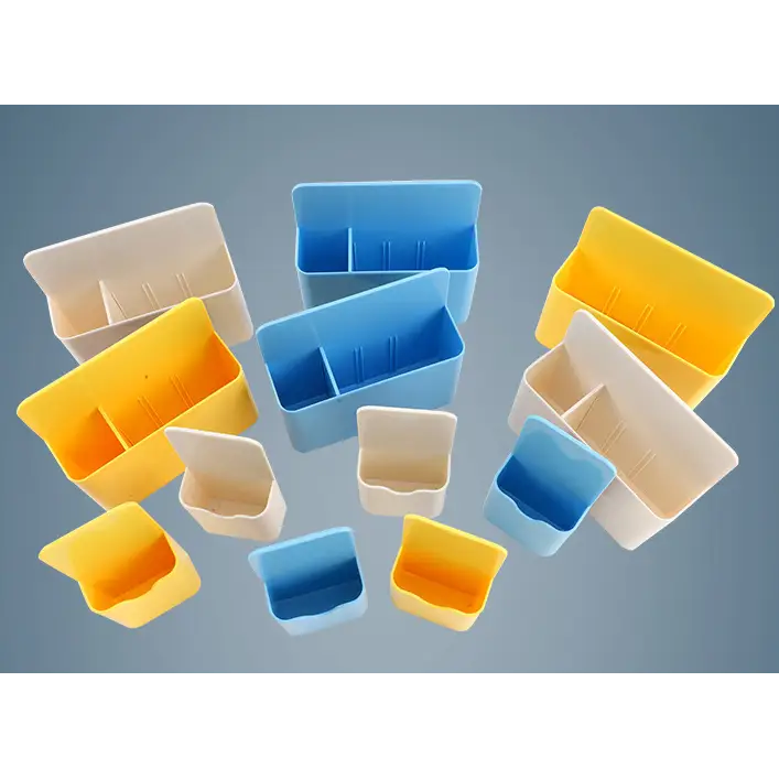 Brightly colored plastic storage bins in yellow, blue, and beige with divided compartments.