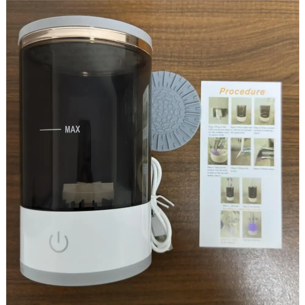White and gold-accented cylindrical ultrasonic cleaner with a transparent black body, marked ’max’ on the side.