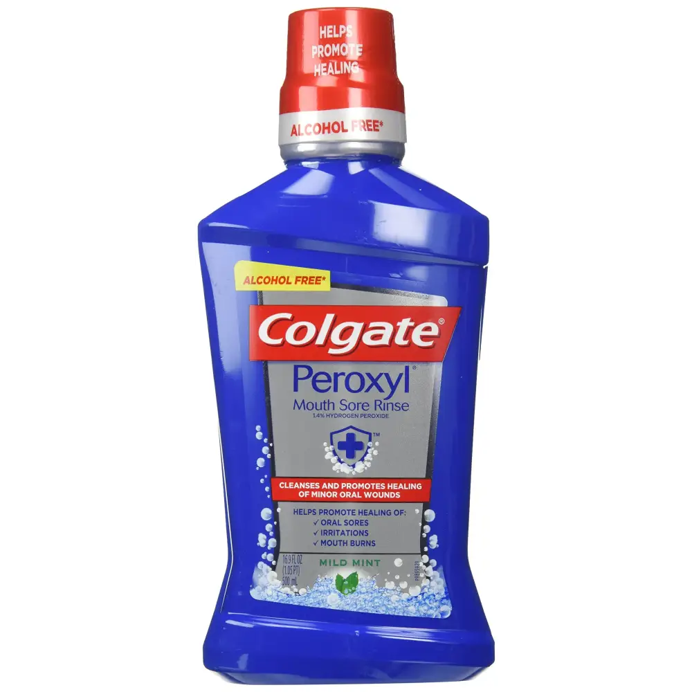 Blue plastic bottle of colgate peroxyl mouth sore rinse with a red cap and silver band, labeled as alcohol-free mild mint.