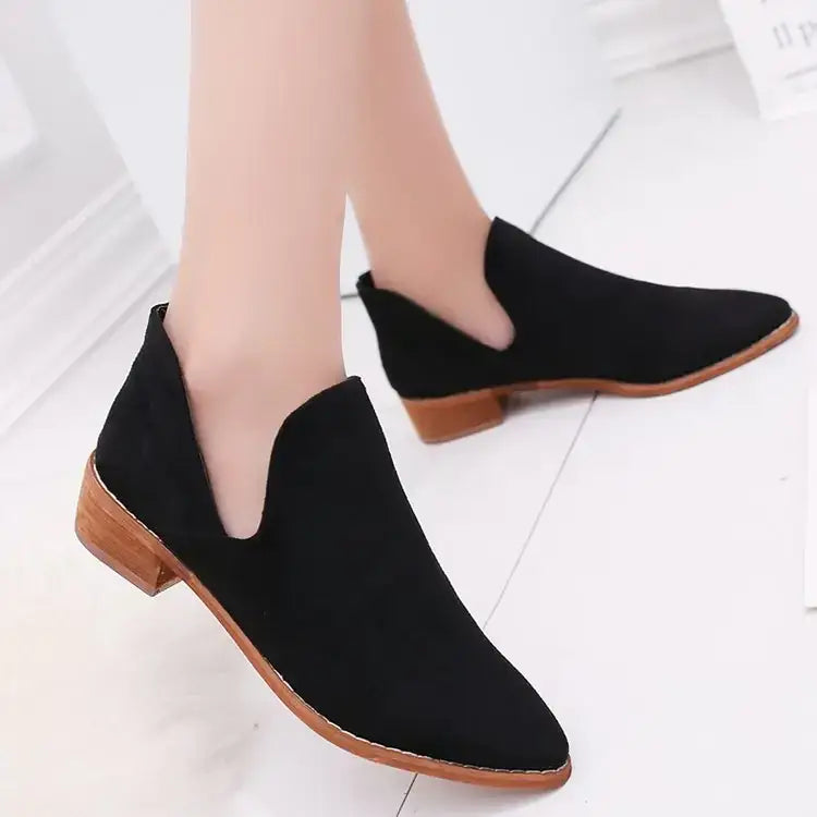 Black suede ankle boots with a low wooden block heel and contrasting tan stitching.