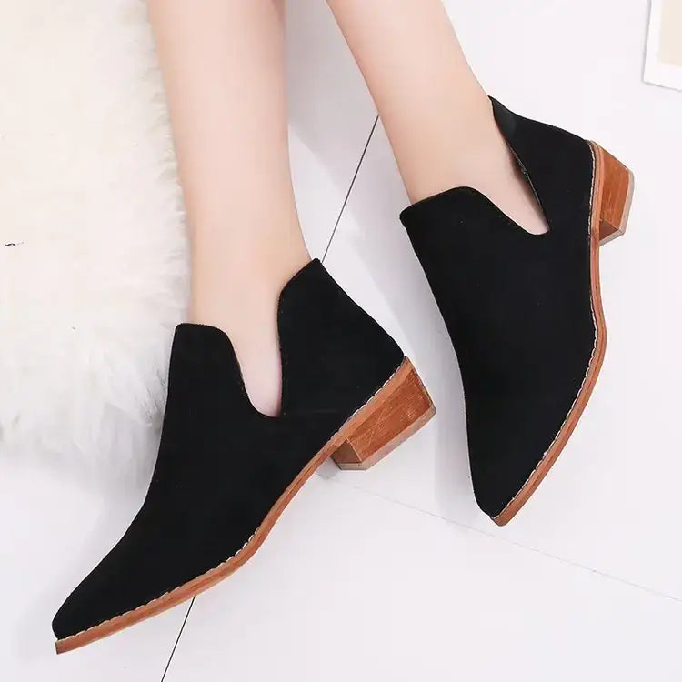 Black suede ankle boots with a pointed toe and wooden block heel.