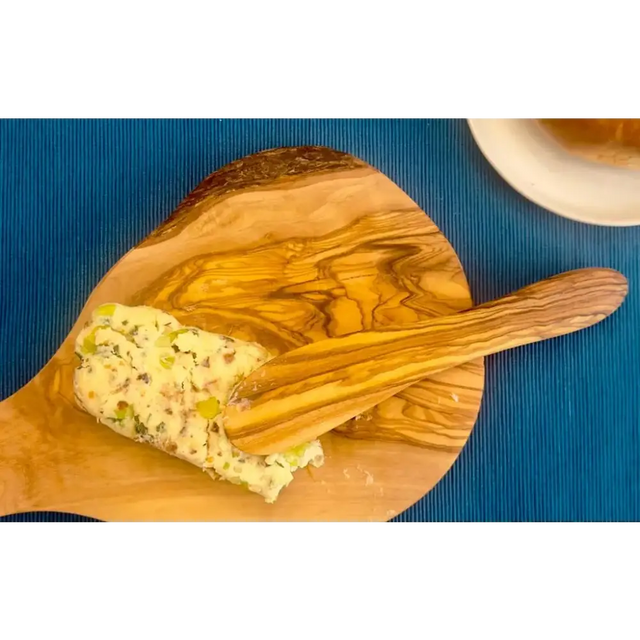 A rustic olive wood cutting board with a natural, swirling grain pattern and a smooth, polished surface.