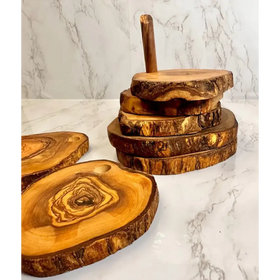 Stack of rustic olive wood cutting boards with natural bark edges and warm golden-brown tones.