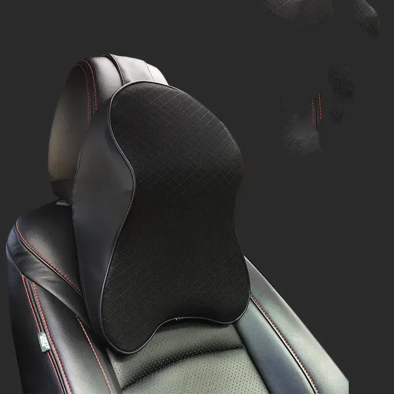 Black ergonomic neck pillow with textured surface and red stitching, designed for car seat use.