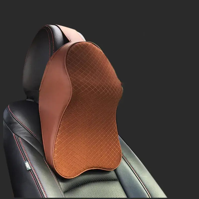 Brown quilted car headrest pillow with black leather trim.