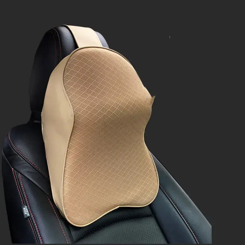 Beige contoured car headrest pillow with diamond-stitched fabric and black leather trim.