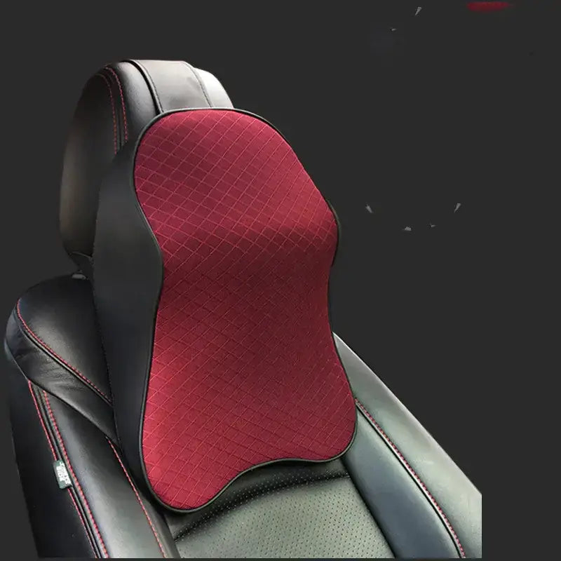 Red quilted memory foam neck pillow with black leather trim and red stitching, designed for ergonomic support.