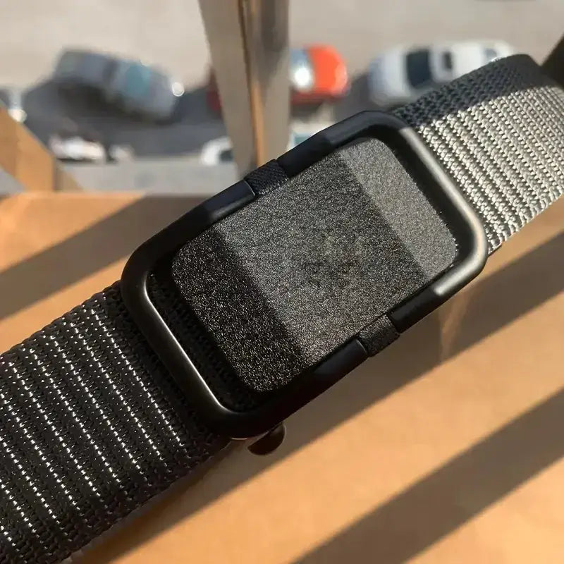 Black nylon belt with a matte black plastic buckle featuring a textured, non-slip surface.