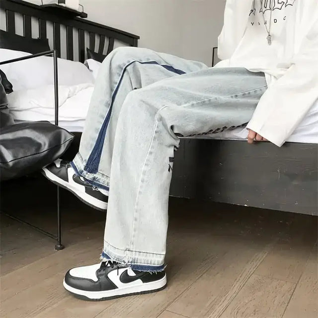 Light-wash denim jeans with dark blue side stripes and frayed hems.