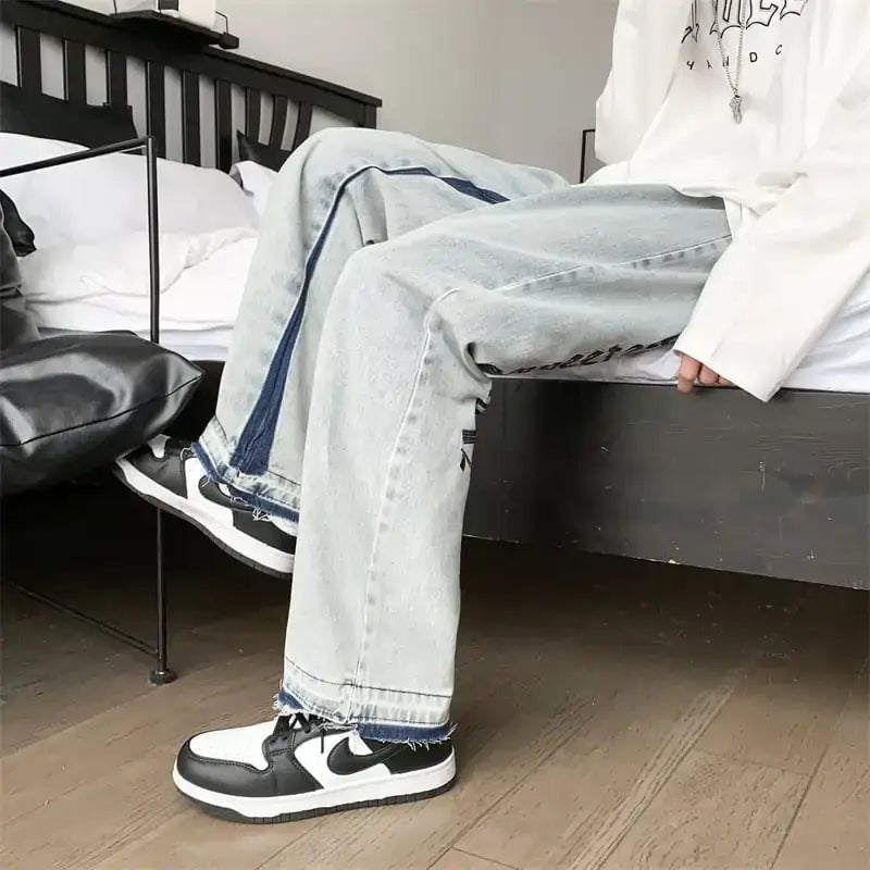 Light-wash denim jeans with dark blue side stripes and frayed hems.