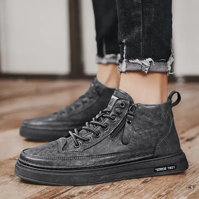 Black high-top sneakers with a distressed leather finish, featuring laces and a zipper on the side.
