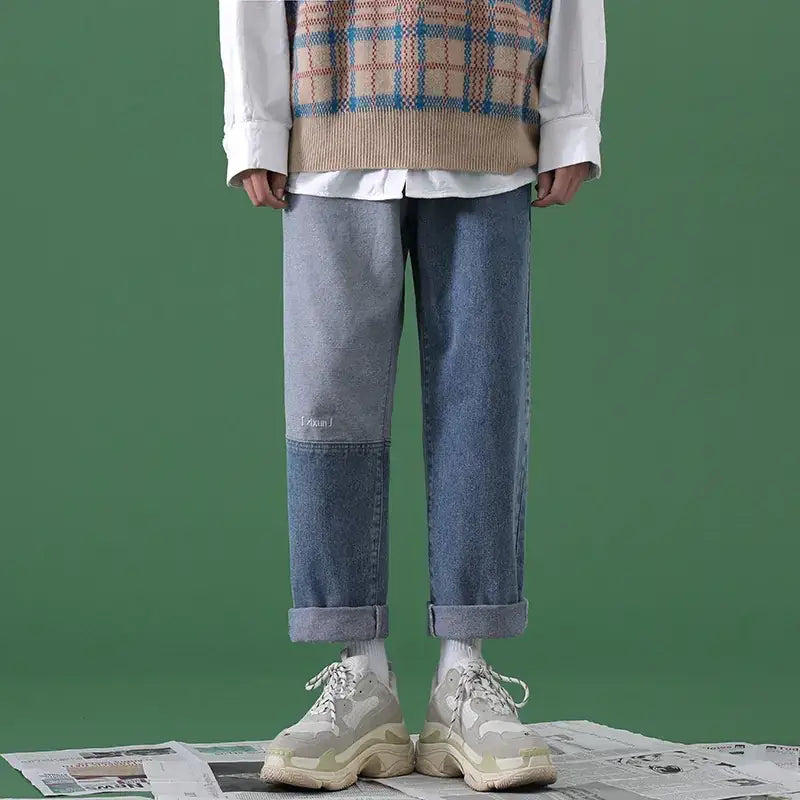 Light-wash denim jeans with a patchwork design featuring darker blue panels and subtle stitching details.