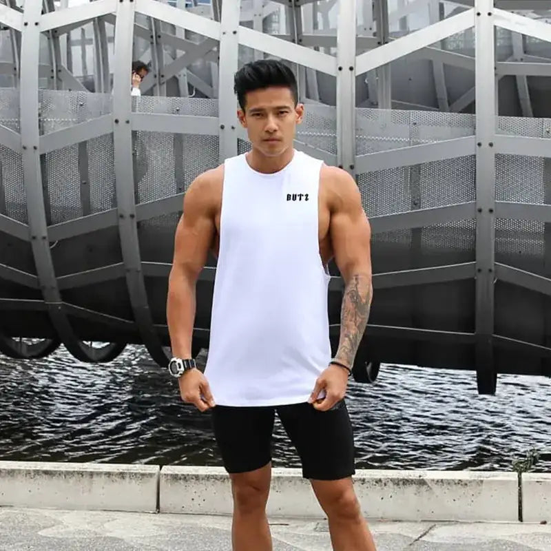 White sleeveless athletic tank top with black ’but2’’ logo on the chest