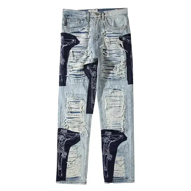 Light-wash denim jeans featuring distressed, ripped patches with black fabric overlays and white line drawings of crucified figures.