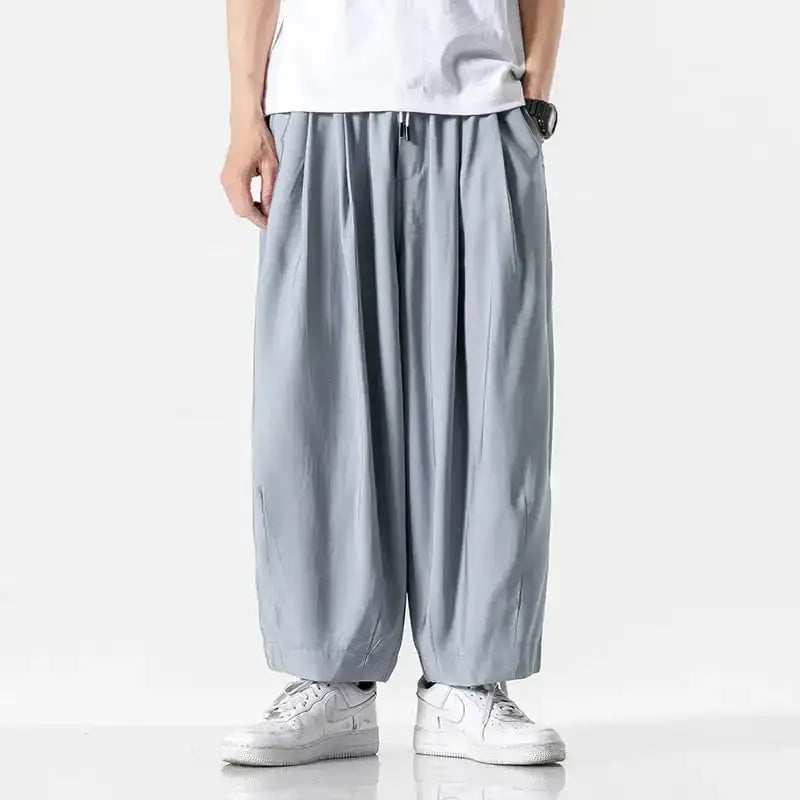 Light gray, loose-fitting pants with a relaxed, flowing silhouette and elastic waistband.