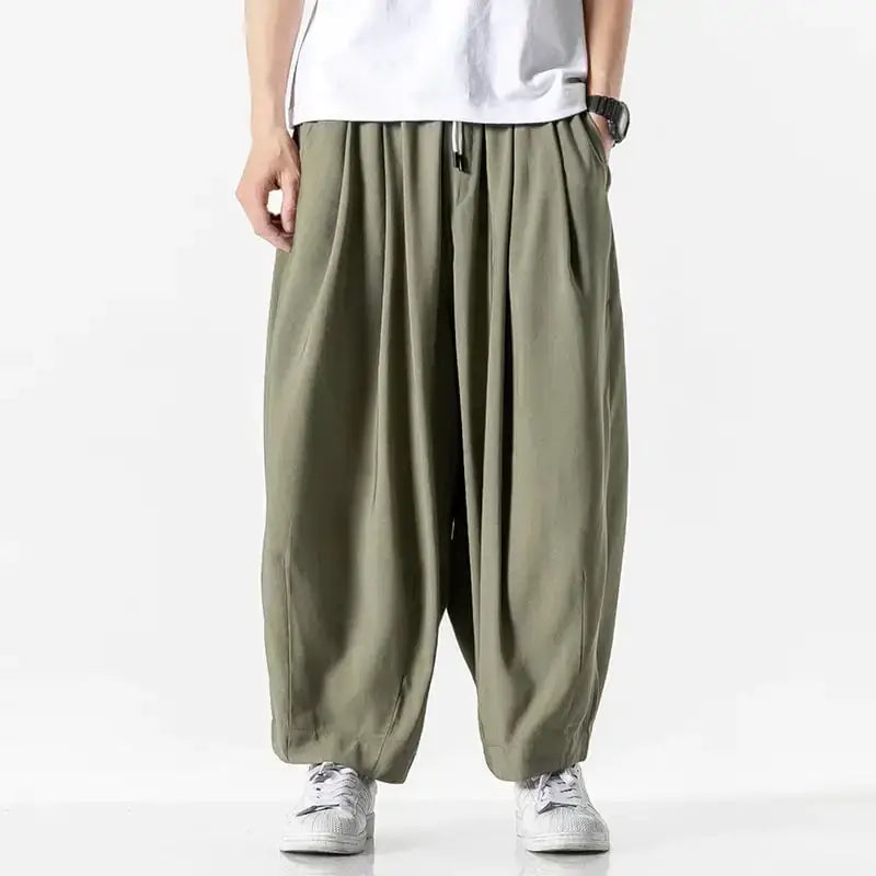 Olive green loose-fitting pants with a drawstring waist and elastic cuffs.