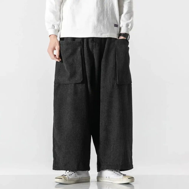 Black corduroy wide-leg pants with large patch pockets.