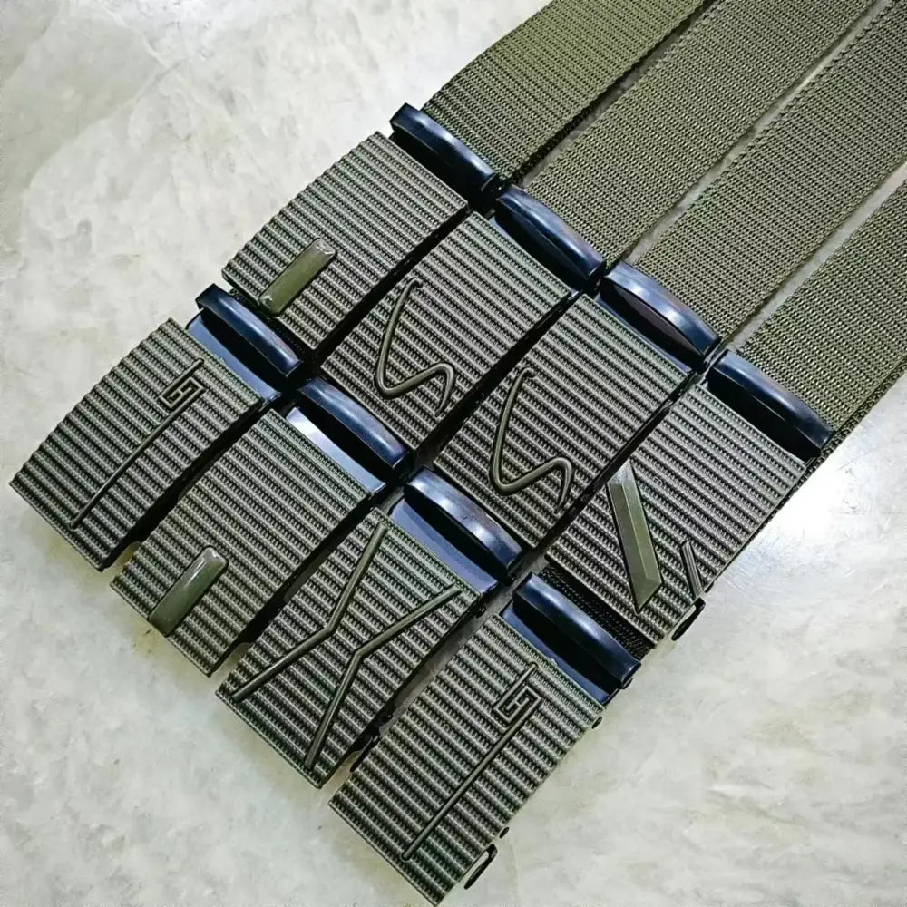 Olive green woven belt with black plastic buckle featuring embossed geometric designs.