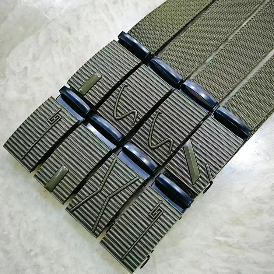Olive green woven belt with black plastic buckle featuring embossed geometric designs.